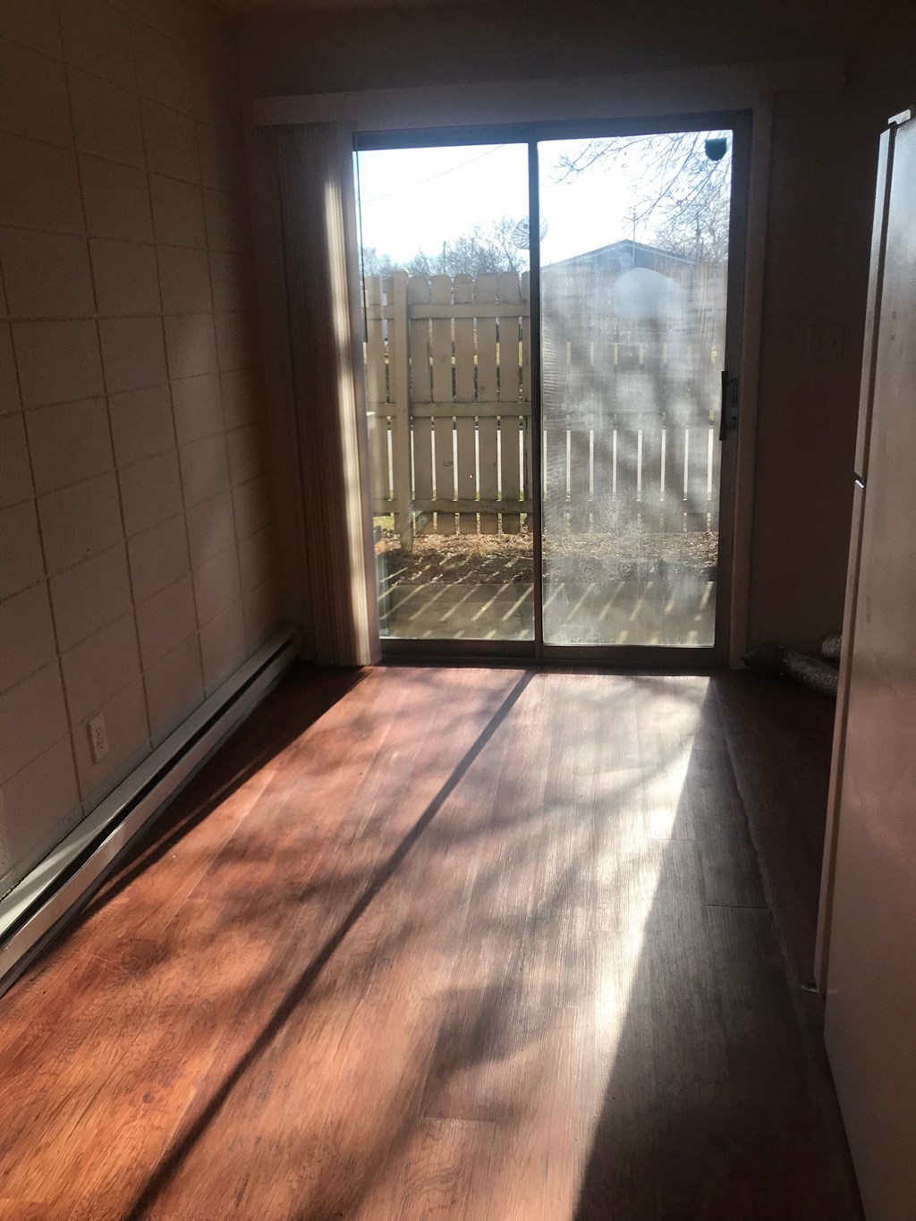 A room with a wooden floor and sliding glass doors.
