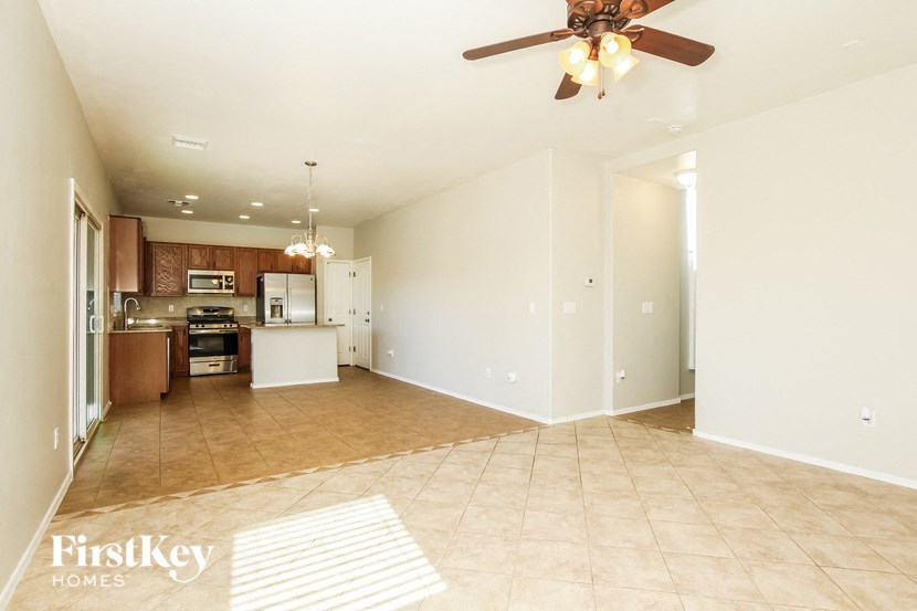 an empty kitchen and living room with a ceiling fan