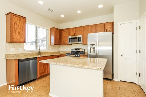 a kitchen with an island and a stainless steel refrigerator