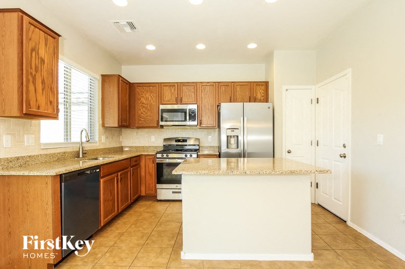 a kitchen with wooden cabinets and a counter top and a refrigerator