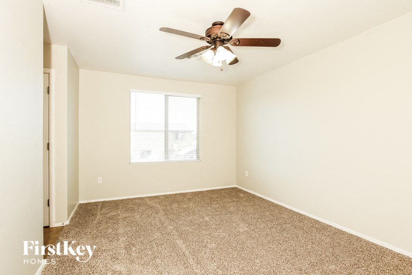 a bedroom with carpet and a ceiling fan