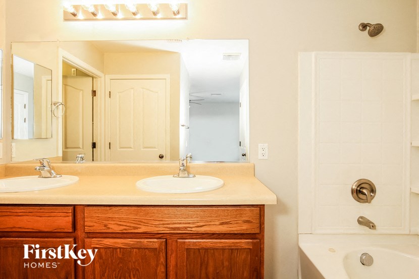 a bathroom with two sinks and a shower and a mirror