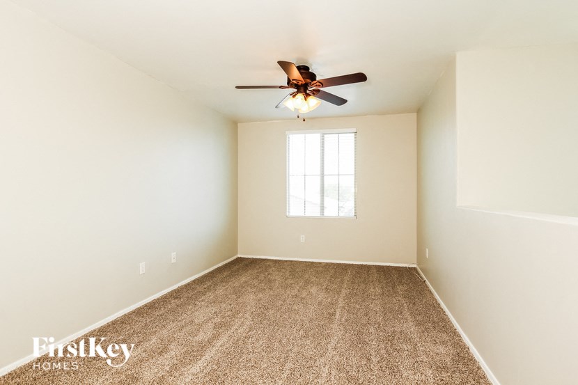 a room with carpet and a ceiling fan