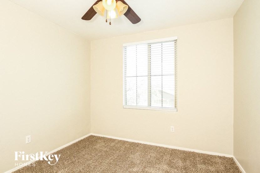 a bedroom with a ceiling fan and a window
