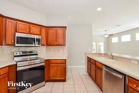 A kitchen with wooden cabinets and a stainless steel dishwasher.