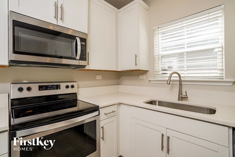 a kitchen with white cabinets and a sink and a microwave
