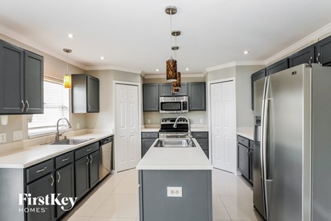 A modern kitchen with a stainless steel refrigerator and a central island.