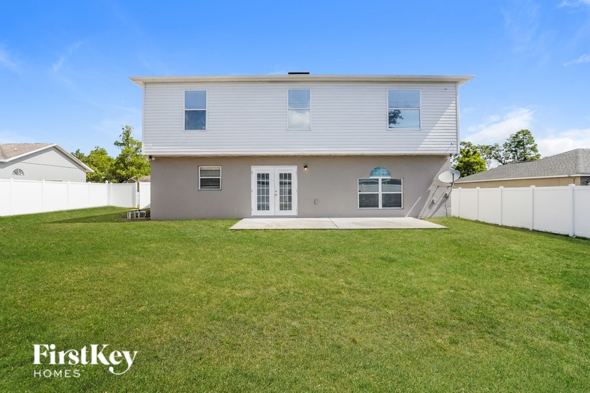 A house with a white fence and a grassy yard.