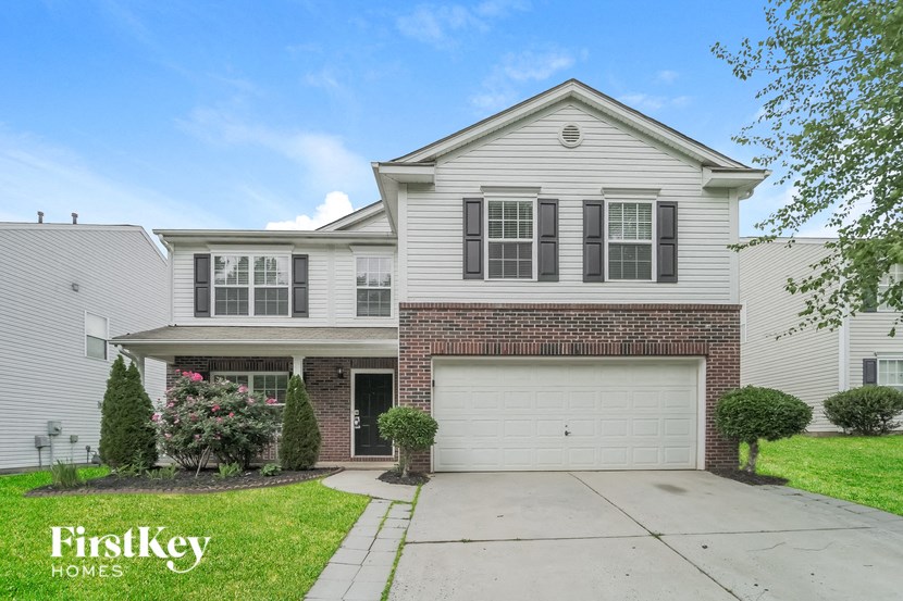 a white and brick house with a white garage door