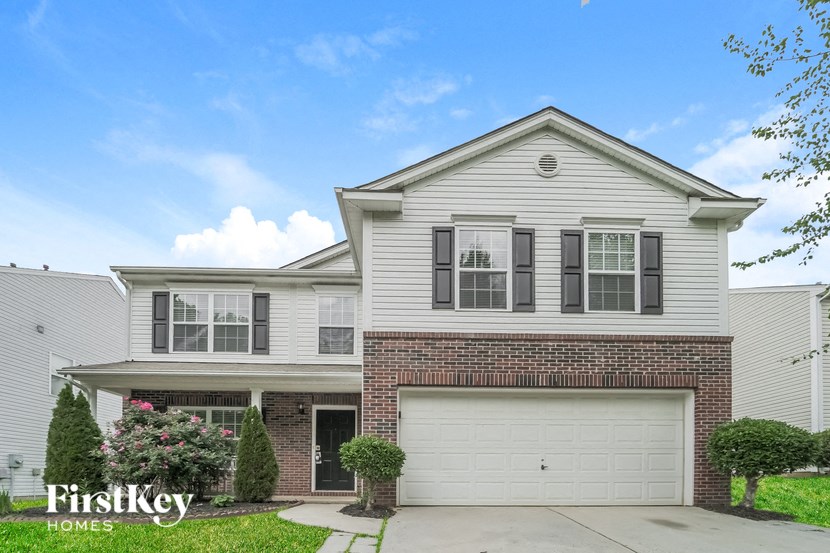 a white and brick house with a white garage door