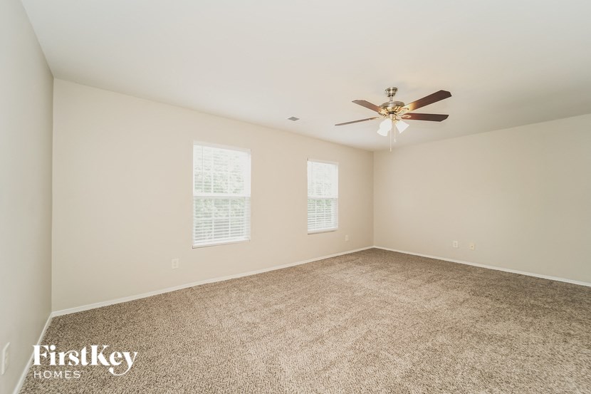 a room with carpet and a ceiling fan