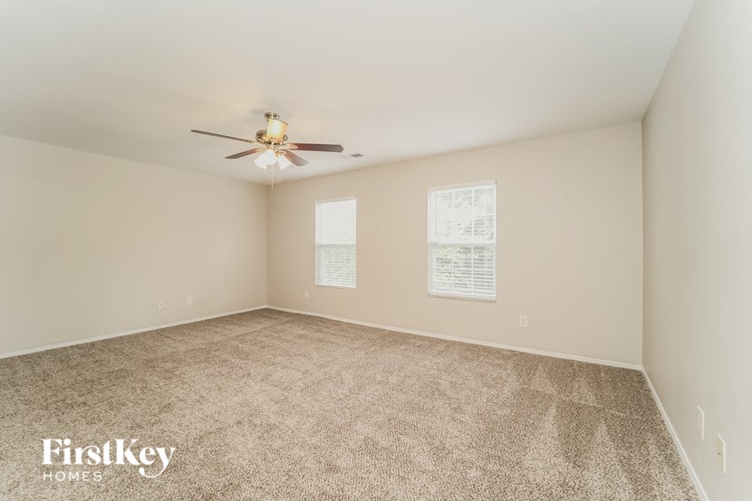 a room with carpet and a ceiling fan