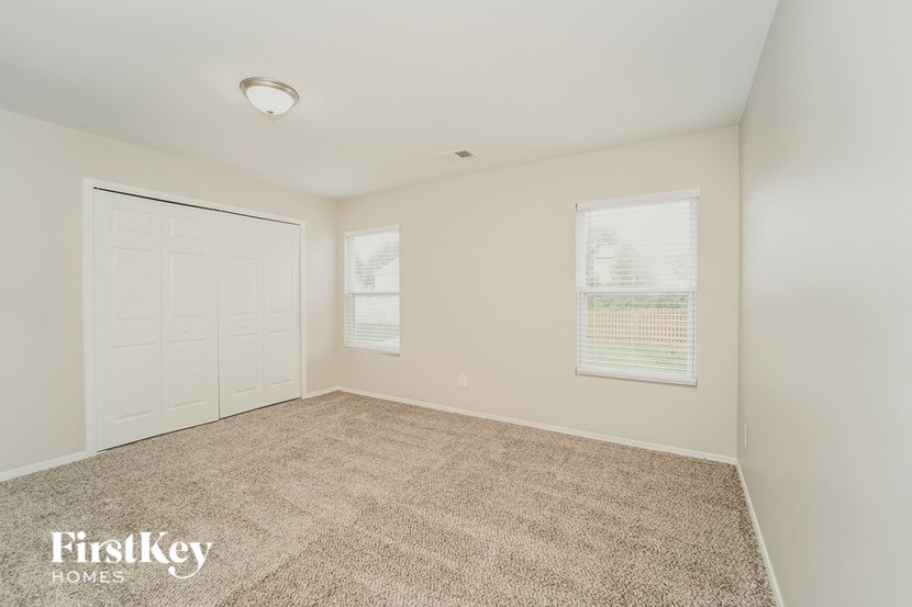a bedroom with a carpeted floor and a white door