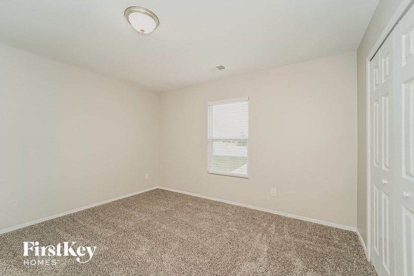 an empty room with carpet and a window