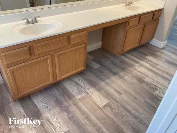a bathroom with a sink and wooden floors