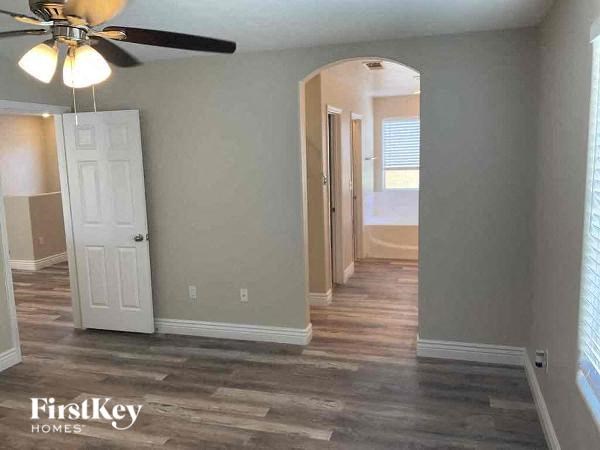 a empty living room with a ceiling fan and a white door