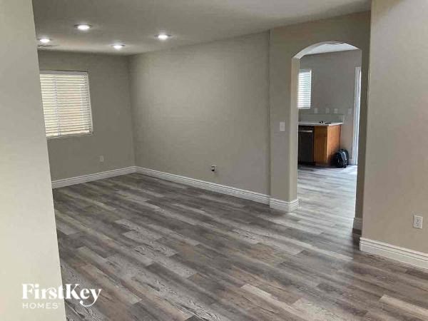 an empty living room with a hard wood floor