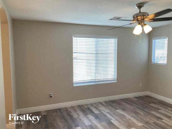 a empty room with a ceiling fan and a window