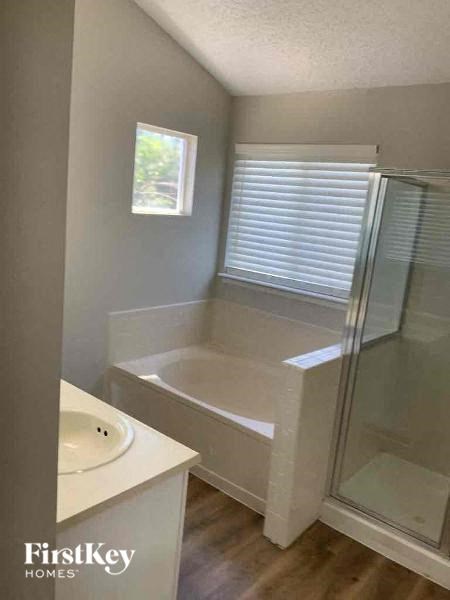 a bathroom with a tub and a shower and a sink