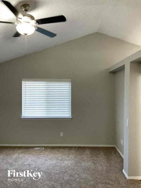 an empty room with a ceiling fan and a window
