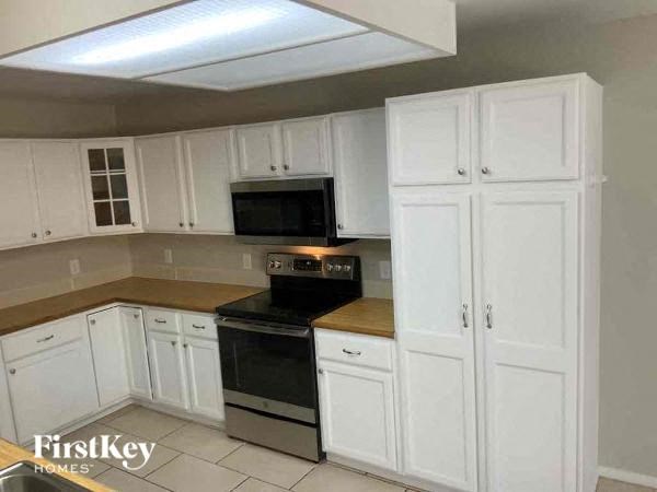 a kitchen with white cabinets and a black stove