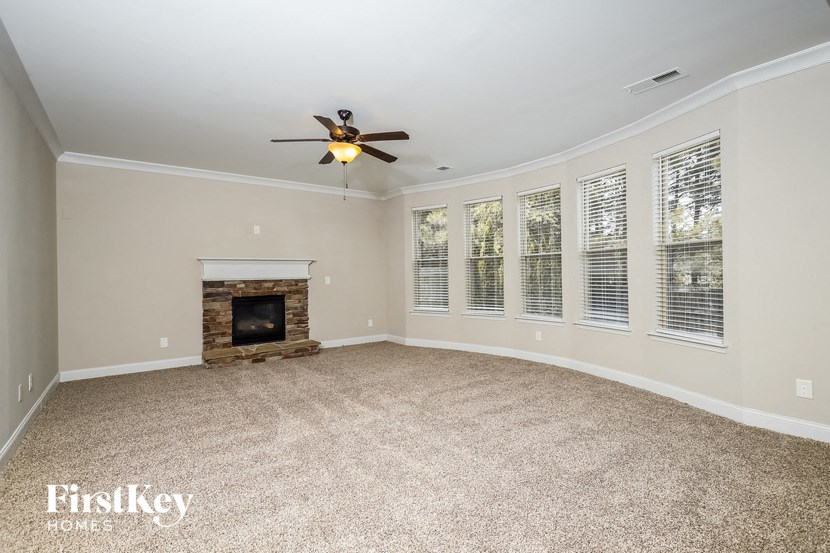 a living room with a fireplace and a ceiling fan