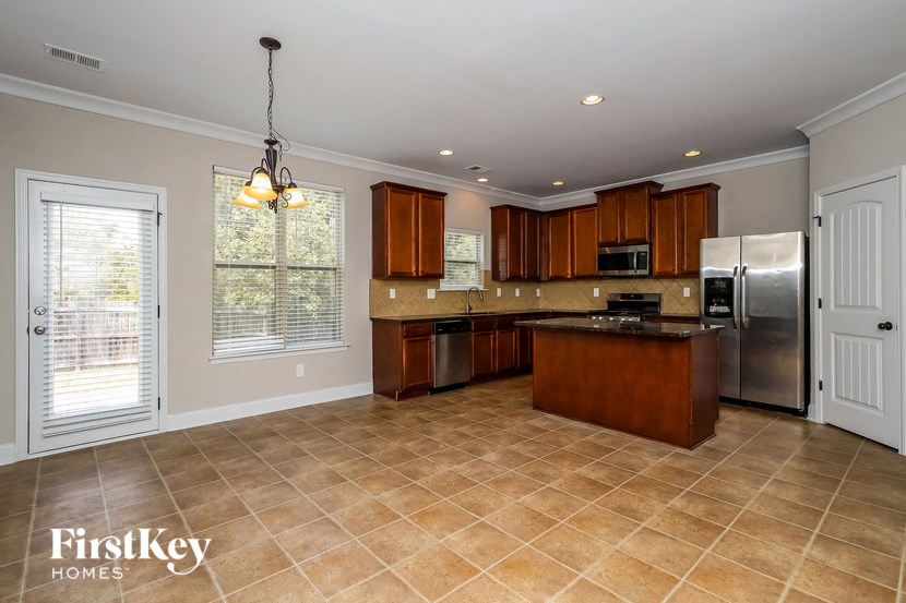 a large kitchen with stainless steel appliances and tile flooring