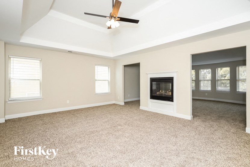 a living room with a fireplace and a ceiling fan