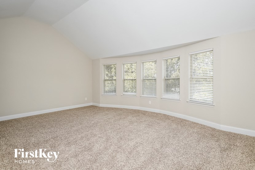 a bedroom with a carpeted floor and five windows