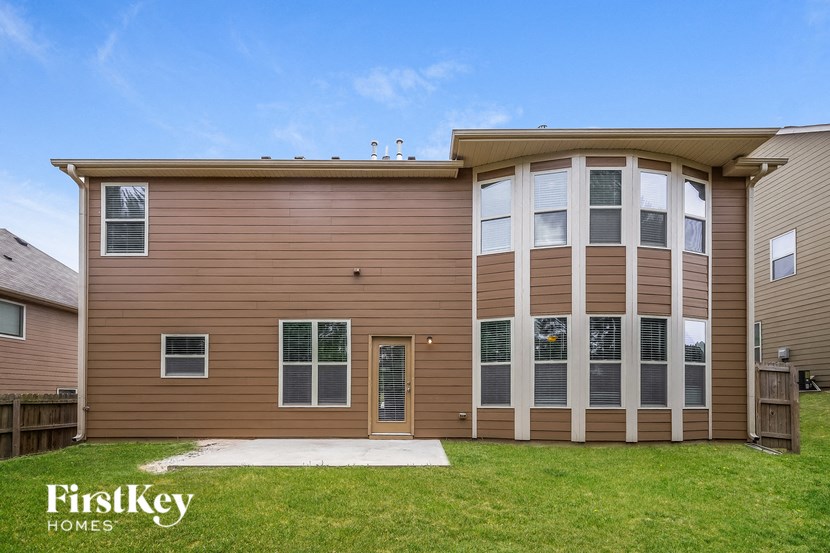 the front of a house with brown siding and a yard