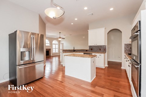 an open kitchen with stainless steel appliances and white cabinets