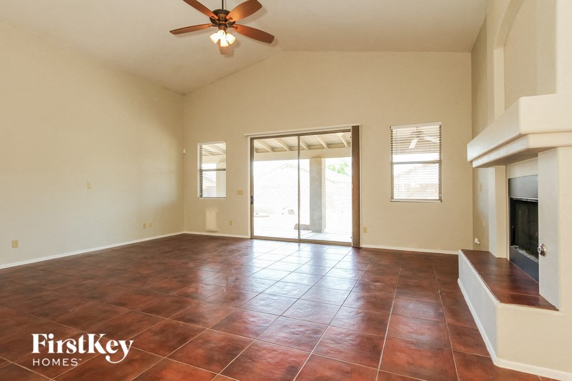 A room with a brown floor and a ceiling fan.