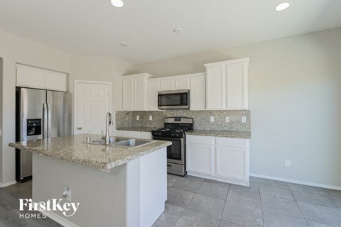 A kitchen with a granite countertop and white cabinets.