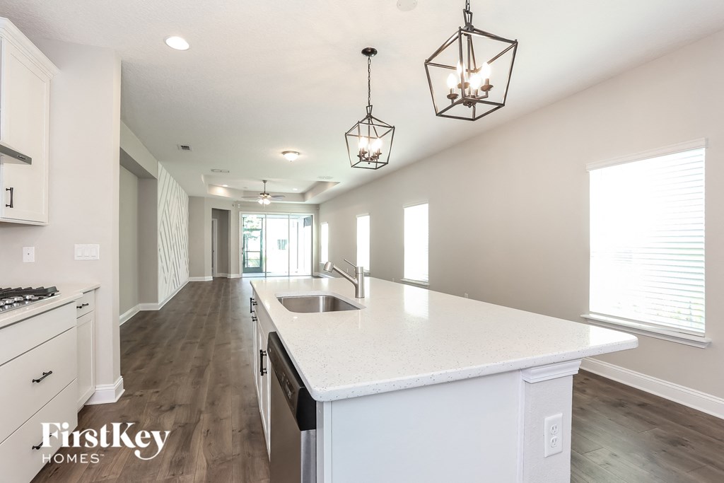 a white kitchen with a white counter top and a sink