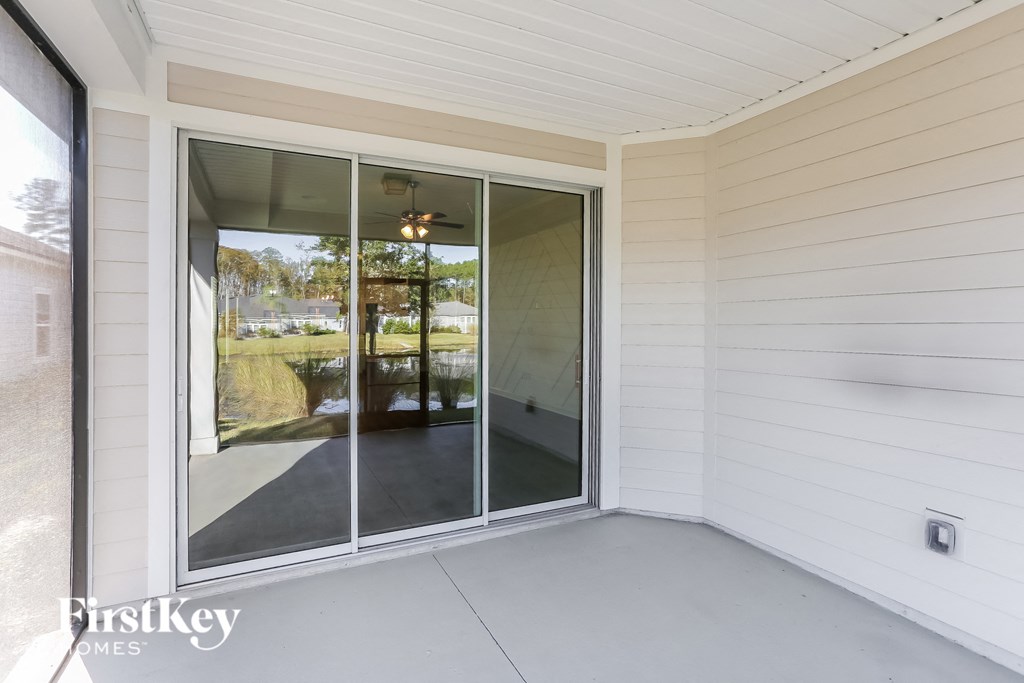 a covered patio with sliding glass doors in a white house