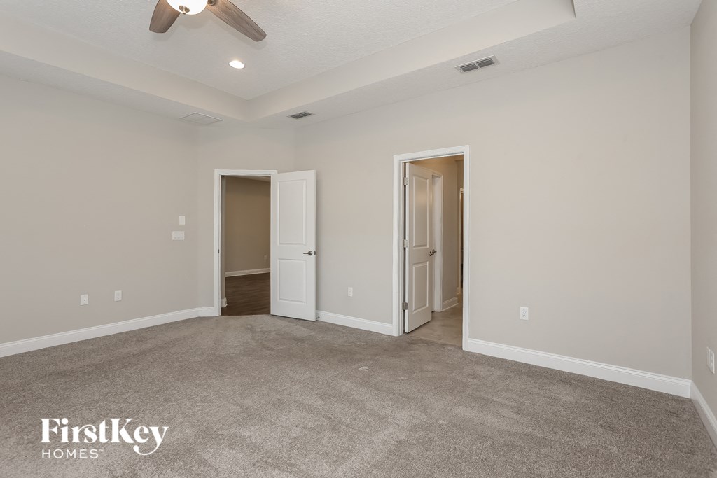 a living room with carpet and a ceiling fan