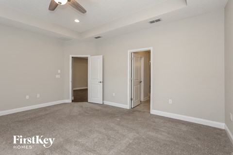 a living room with carpet and a ceiling fan