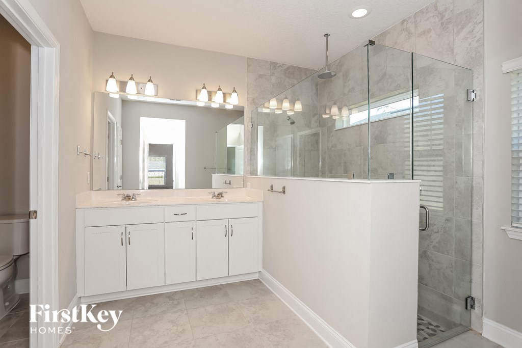 a large white bathroom with a large shower and two sinks