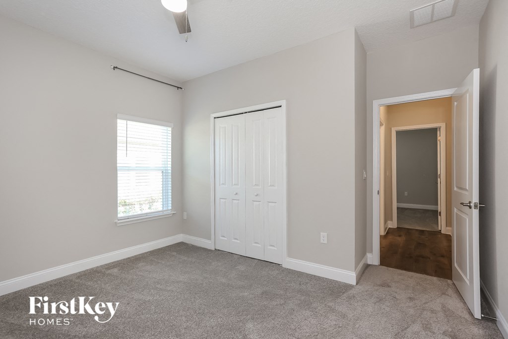 a bedroom with a closet and a door to a hallway