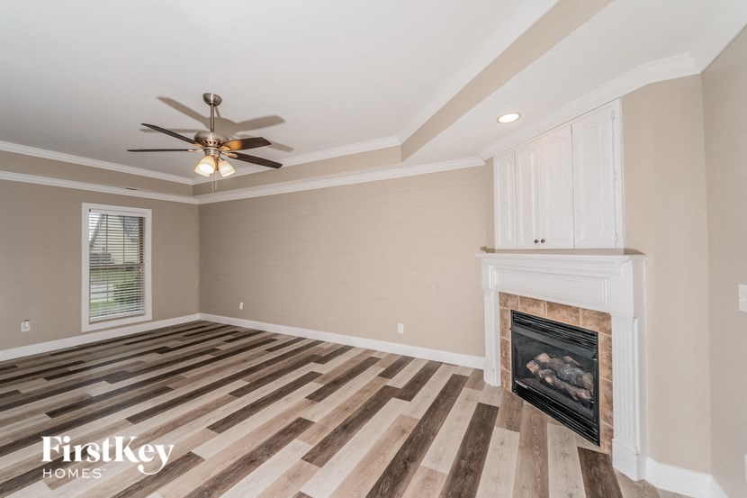 a living room with a fireplace and a ceiling fan