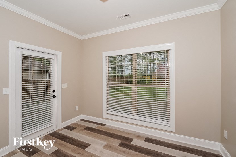 the living room has a large window with blinds and a door to the backyard