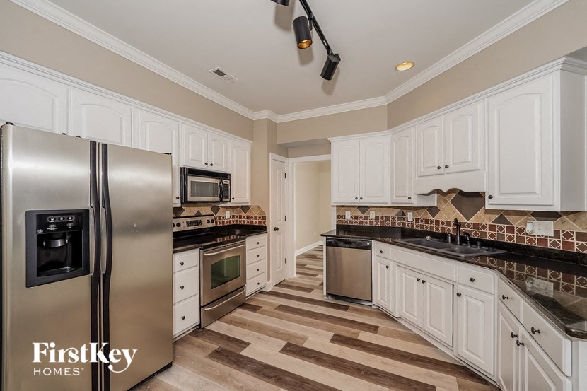 a kitchen with white cabinets and stainless steel appliances