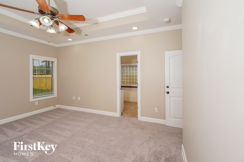a living room with carpet and a ceiling fan