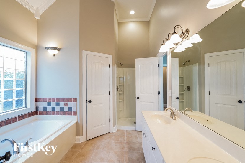 a bathroom with a tub and a sink and a mirror