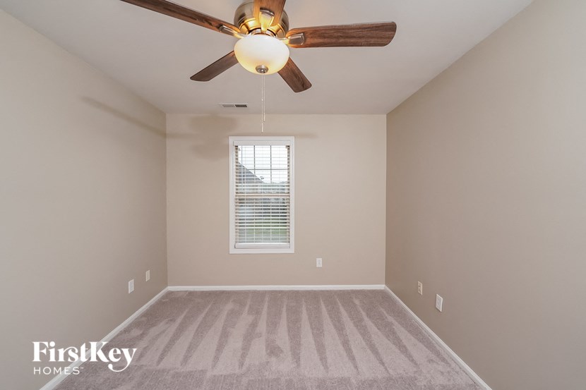the master bedroom has a ceiling fan and carpeted flooring