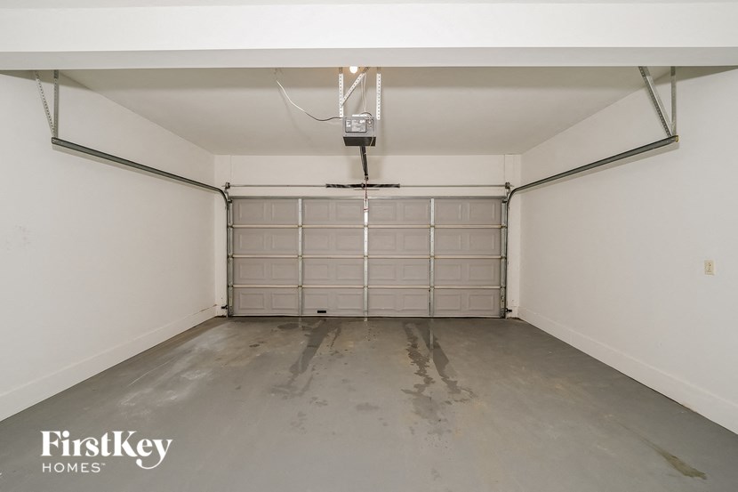 a garage with white walls and a dirty floor