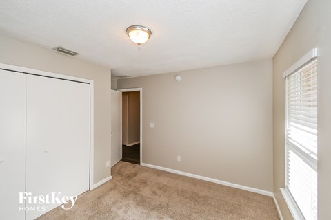 a bedroom with a closet and a door to a hallway