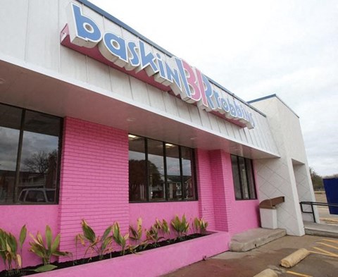 The exterior of a building with a pink and white facade.