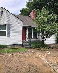 A house with a red door and a tree in front.