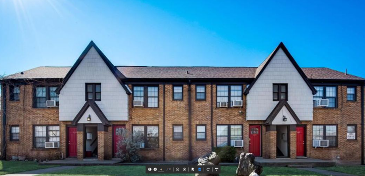 a row of brick houses with red doors and white roofs